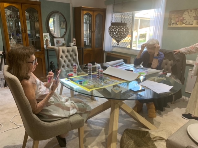 Karen & Jean working on their respective diamond art pieces around the dining table